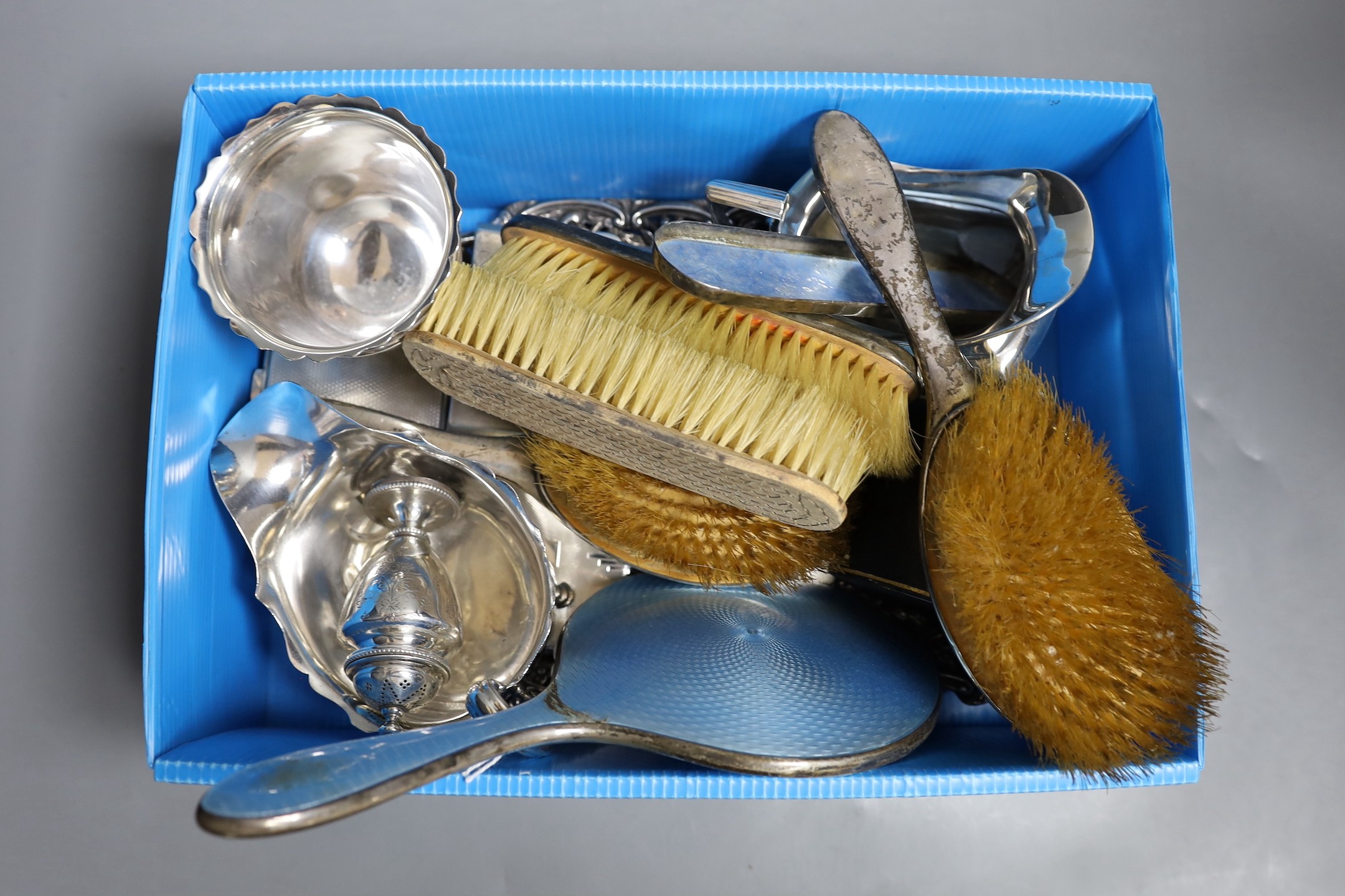 A collection of small silver including a repousse dressing tray, cream jug, sugar bowl, pepperette, sauceboat, two cigarette cases, compact, napkin ring and a mounted enamel mirror and brush set, weighable silver 41.5oz.